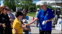 Volunteer hands out manatee stickers at ManateeFest 2022.